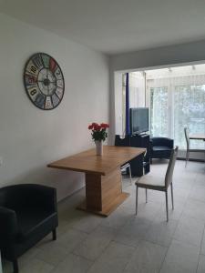 a living room with a table and a clock on the wall at Viktoria Budget Hostel in Zürich