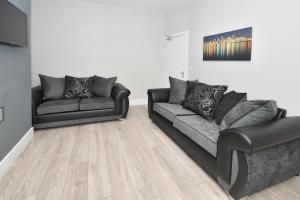 a living room with two couches and a television at Townhouse @ Lawton Street Crewe in Crewe