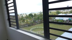 an open window with a view of a yard at The See Apartments in Trou aux Biches