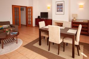 een woonkamer met een tafel en stoelen en een bank bij Nortada Suite Beach Apartment T2 in Lagos