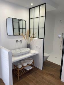 ein weißes Badezimmer mit einem Waschbecken und einem Spiegel in der Unterkunft Villa el Molino in Los Cerrillos
