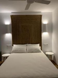 ein Schlafzimmer mit einem großen weißen Bett mit zwei Tischen in der Unterkunft Villa el Molino in Los Cerrillos