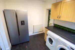 eine Küche mit einem Kühlschrank und einer Waschmaschine in der Unterkunft Birches House in Ford Green
