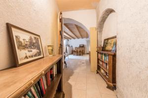 um corredor com uma estante de livros com livros em Agriturismo Al Gallo Nero Miele em Tenno