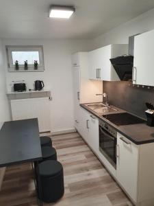uma cozinha com armários brancos e um forno com placa de fogão em Haus Fasanerie em Fulda