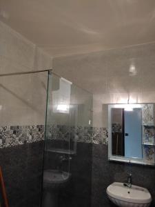 La salle de bains est pourvue d'un lavabo et d'une douche en verre. dans l'établissement Résidence Assafae Harhoura, à Temara