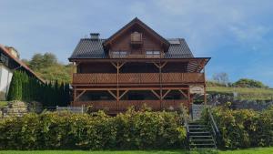 a large wooden house with stairs leading up to it at Tęczowe Wzgórze in Szczawnica +46 photos