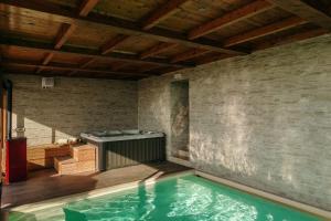 a swimming pool with a hot tub in a room at Villa Di Sotto in Castelnuovo Berardenga