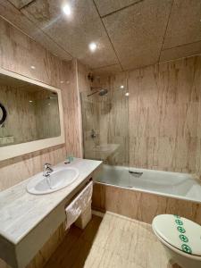 La salle de bains est pourvue d'un lavabo, d'une baignoire et de toilettes. dans l'établissement Hotel & Restaurant Figueres Parc, à Figueres