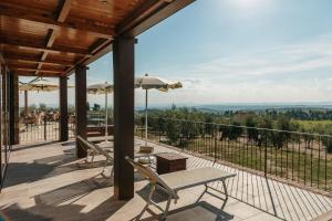 a patio with a table and chairs on a balcony at Villa Di Sotto in Castelnuovo Berardenga