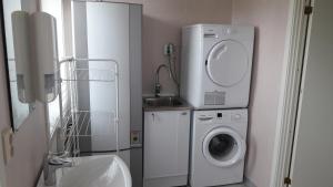 a bathroom with a washing machine and a sink at Knihsgården in Rättvik