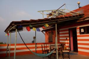a house with a hammock and a table and chairs at The Nest Guest House in Changunarayan