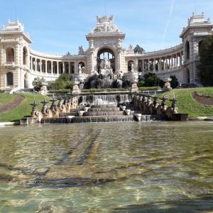 un bâtiment avec une fontaine devant lui dans l'établissement LE LOGIS DU PALAIS, à Marseille