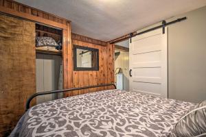a bedroom with a bed and a wooden wall at Cozy Goshen Farmhouse about 9 Mi to Amish Acres in Goshen