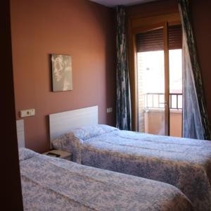 a hotel room with two beds and a window at HOSTAL BURGALES in Milagro +45 photos