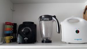 um liquidificador sentado num balcão de cozinha ao lado de um liquidificador em Lindo apartamento em Frente ao mar na Ilha Comprida em Ilha Comprida