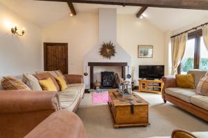 a living room with two couches and a fireplace at The Old Stables in Yeovil