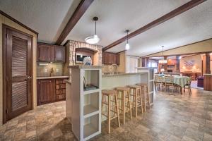 a kitchen with a bar and a dining room at Monett Family Ranch Home with Fireplace and Huge Deck! in Monett