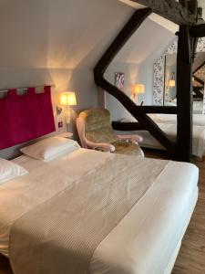 een hotelkamer met een bed en een stoel bij Hotel Le Bon Laboureur in La Charité-sur-Loire
