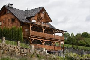 a large wooden house with a black roof at Tęczowe Wzgórze in Szczawnica