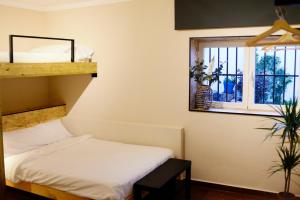 ein Schlafzimmer mit einem Etagenbett und einem Fenster in der Unterkunft Azul añil EL PATIO Casa rural en Alameda in Alameda
