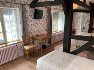a bedroom with two bunk beds and a table and a desk at Hotel Le Bon Laboureur in La Charité-sur-Loire