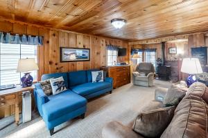 a living room with blue furniture and wooden walls at Backcountry Bungalow in Joseph