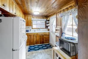 a kitchen with a refrigerator and a tv at Backcountry Bungalow in Joseph