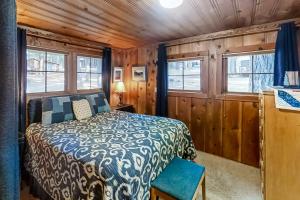 a bedroom with a bed and two windows at Backcountry Bungalow in Joseph