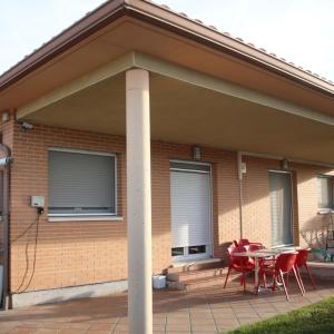 un patio con sillas y una mesa frente a una casa en HOSTAL BURGALES, en Milagro