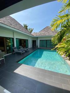 a swimming pool in front of a house at Villa Tara nr Layan Beach in Bang Tao Beach