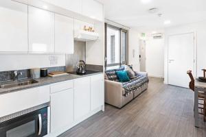 a kitchen and a living room with a couch at Chapter Lewisham in London in London
