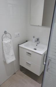 Baño blanco con lavabo y espejo en Calle Alberca 5, Villotel. Madroñal Urb., 03726 Benitachell,, en Teulada