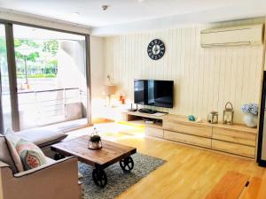 ein Wohnzimmer mit einem Sofa und einem TV in der Unterkunft บ้านแสนคราม in Ban Huai Sai Tai