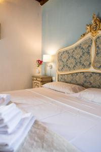um quarto com uma cama branca e uma parede azul em Villa Il Fedino em San Casciano in Val di Pesa