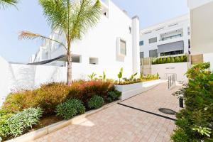 un patio de un edificio blanco con una palmera en Baviera Hills 59, en Caleta de Vélez