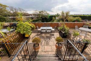 a patio with a table and chairs and plants at Stunning Sea View 2 Bed Apt Terrace Free Parking - Burlington Mansions in Bournemouth