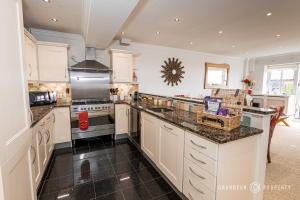 a large kitchen with white cabinets and granite counter tops at Stunning Sea View 2 Bed Apt Terrace Free Parking - Burlington Mansions in Bournemouth