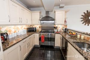 a kitchen with white cabinets and a stove top oven at Stunning Sea View 2 Bed Apt Terrace Free Parking - Burlington Mansions in Bournemouth