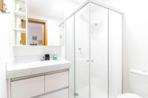 a white bathroom with a shower and a sink at GB37 Excelente Apt 2 Suítes em Guarajuba in Guarajuba +13 photos