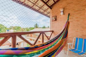 a colorful hammock sitting on a balcony with a chair at GB37 Excelente Apt 2 Suítes em Guarajuba in Guarajuba