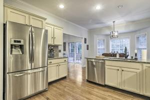 una cucina con frigorifero in acciaio inossidabile e armadietti bianchi di Rustic Pinehurst House with Fire Pit and Game Room a Pinehurst