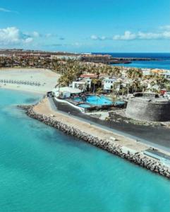 an aerial view of a resort on the beach at Green View Luxury appartment in new complex Pueblo Majorero next to golf course 5 min walk from the Beach and Atlantico Shopping Centre in Caleta de Fuste Next to Cassino and Elba Sara Hotel 2 bedrooms 2 bathrooms huge terace! in Caleta De Fuste