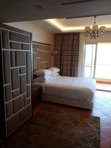 a bedroom with a large white bed and a window at Porto Sokhna chalets in Ain Sokhna