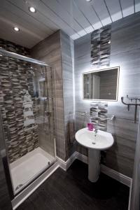 een badkamer met een douche en een wastafel bij Rossall House , For Families & Couples in Blackpool