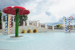 a swimming pool with a red umbrella in the water at Lacqua Diroma Caldas Novas PB Turismo in Caldas Novas