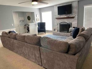 a large brown couch in a living room with a fireplace at Large open space for family fun! in Amarillo