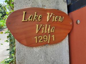 un cartello di legno sul lato di un muro di Lake View Villa a Mirissa