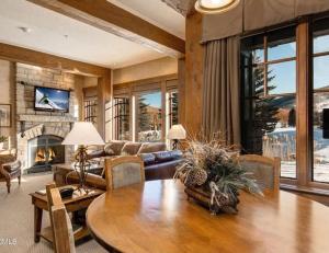 a living room with a table and a fireplace at Private Condos at Hotel Park City in Park City