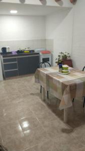 a kitchen with a table in the middle of a room at Amaru Apart in La Consulta